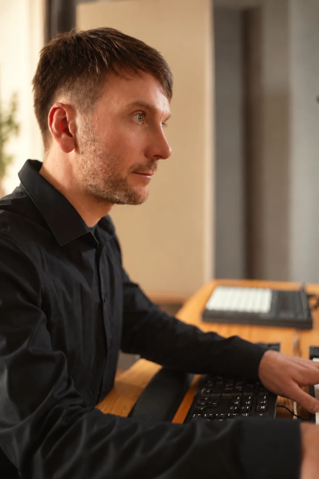 Release-Ready-Check im Tonstudio Leipzig — konzentriertes Seitenprofil an der Tastatur bei der technischen Prüfung