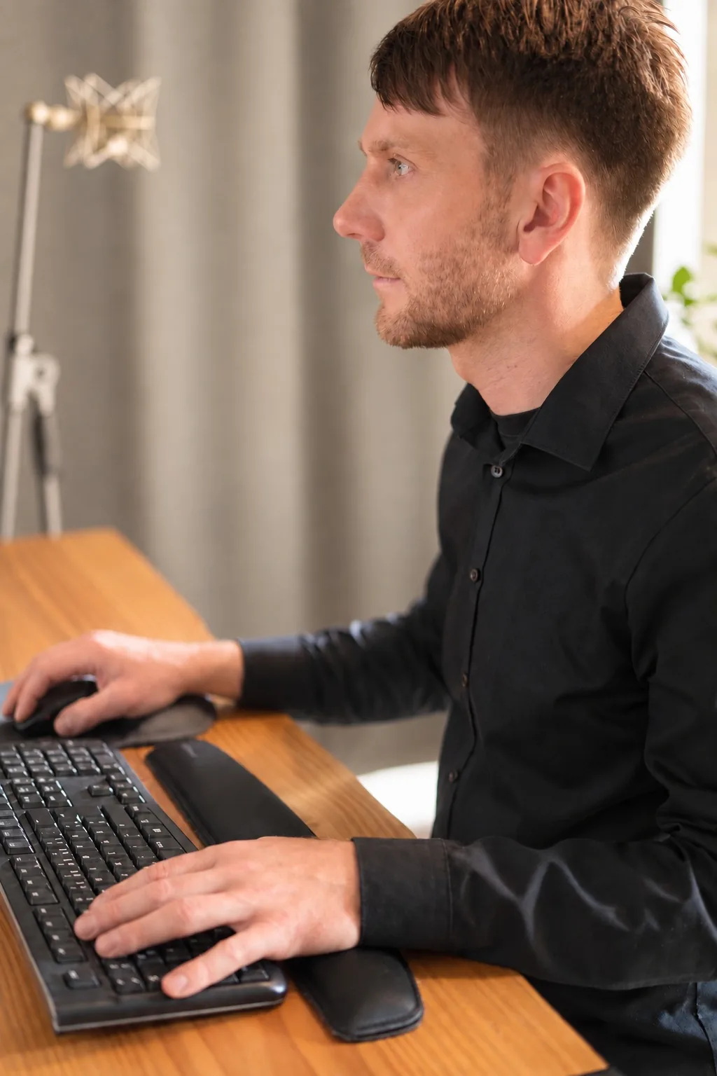 Songdoctoring im Tonstudio Leipzig — konzentriertes Seitenprofil am Arbeitsplatz mit Tastatur
